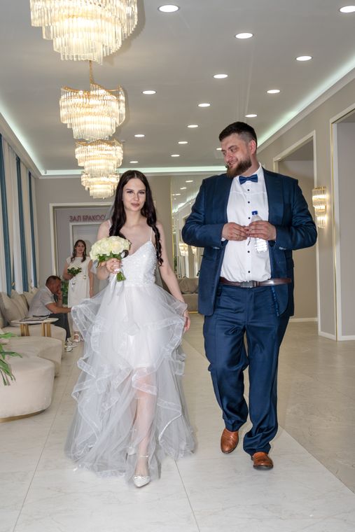 Пара идёт по залу ЗАГСа